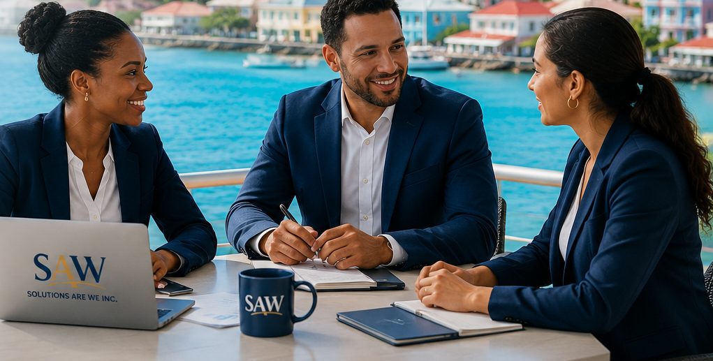 Three colleagues in conversation around a table on a terrace overlooking a Caribbean harbour and waterfront town.